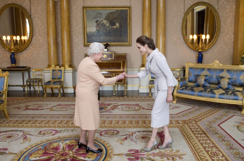 Reverencia protocolar de Angelina Jolie hacía a la Reina Isabel en el palacio de Buckingham, antes de ser nombrada como Dama Honorífica por su combate contra la violencia sexual.Reverencia protocolar de Angelina Jolie hacía a la Reina Isabel en el palacio de Buckingham, antes de ser nombrada como Dama Honorífica por su combate contra la violencia sexual.